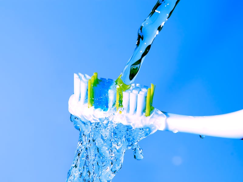 A toothbrush under running water.
