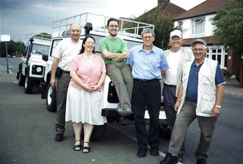 Tom Little, third from right, of the International Assistance Mission, poses in front of donated vehicles in London. Ten members of a medical team, including Little, were shot in Afghanistan.