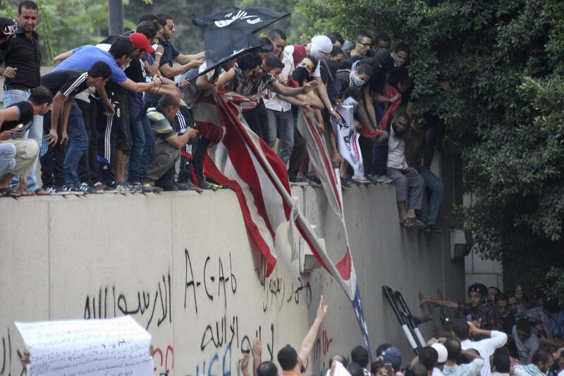 Protesters destroy an American flag pulled down from the U.S. embassy in Cairo, Egypt, Tuesday, Sept. 11, 2012. Egyptian protesters, largely ultra conservative Islamists, have climbed the walls of the U.S. embassy in Cairo, went into the courtyard and bro