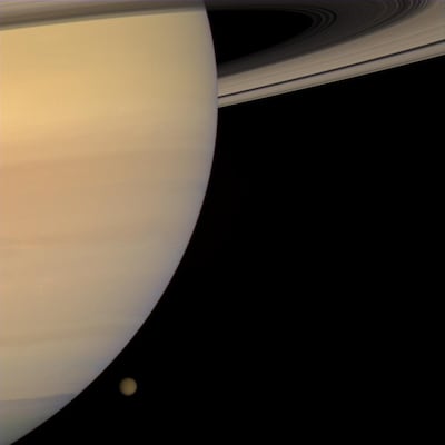 The solar system's second-largest planet, Saturn, is orbited by the second-largest moon, Titan, in this 2008 photo taken by NASA’s Cassini spacecraft. The deep-freeze planet may harbor traces of chemical predecessors to life, or even evidence of life itse