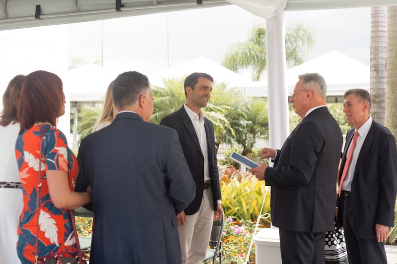 Elder Ulisses Soares of the Quorum of the Twelve Apostles presents a leather-bound copy of the Book of Mormon to Ricardo Queiroz.