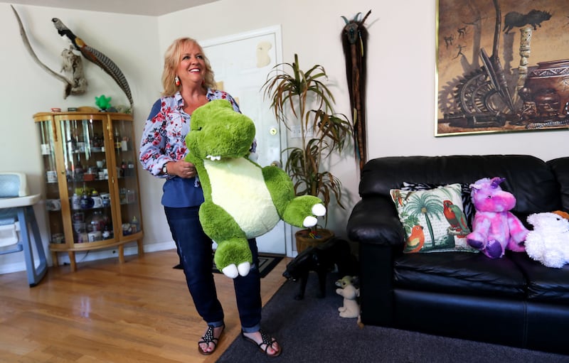Gun rights activist Janalee Tobias holds a stuffed dinosaur at her home in South Jordan on Friday, July 13, 2018. Tobias says she was punked by actor Sacha Baron Cohen for his upcoming Showtime series "Who Is America?" Here she re-creates how a stuffed di