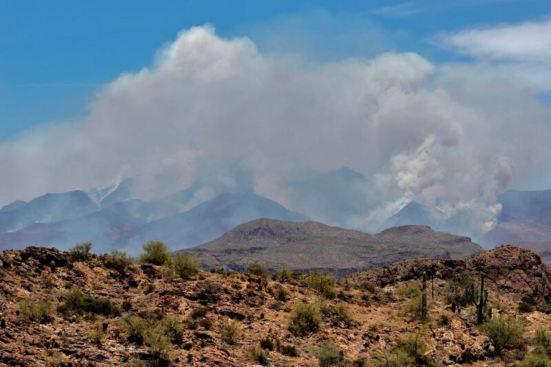 A portion of the Bush fire burns through the Tonto National Forest, Tuesday, June 16, 2020, as seen from Apache Junction, Ariz.