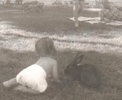 A young Gail Harding plays with a bunny.