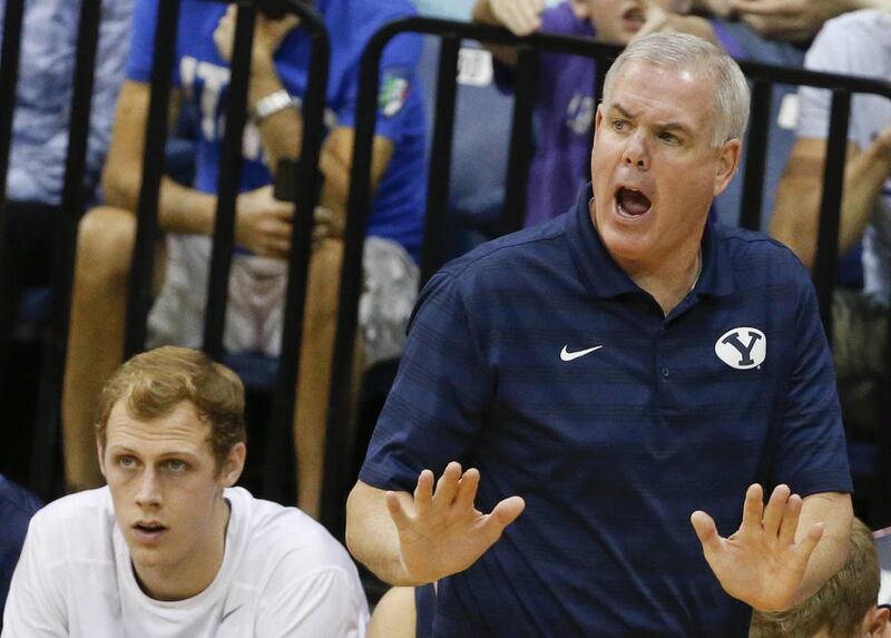 BYU head coach Dave Rose, right, calms down his team during the first half of an NCAA college basketball game against San Diego, Saturday, Jan. 24, 2015, in San Diego.