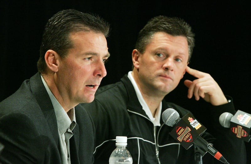 Utah football coaches Urban Meyer, left, and Kyle Whittingham talk with the media
