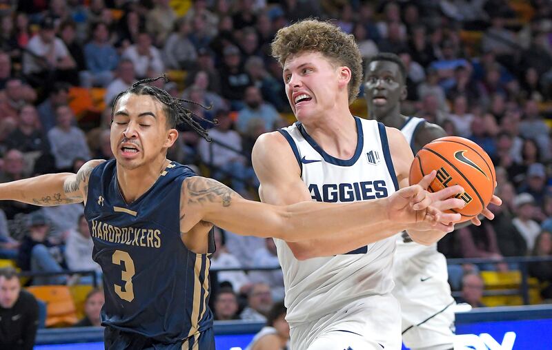 Utah State guard Mason Falslev, front right, drives to the basket as South Dakota School of Mines guard Alejandro Rama (3) defends during the second half of an NCAA college basketball game Monday, Nov. 6, 2023, in Logan, Utah.