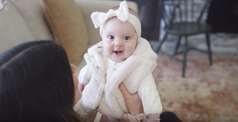 Baby Willow Pestridge smiles at the camera while being held by her mother, Savannah Pestridge, in BYU Noteworthy's newest music video.