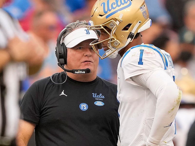 UCLA coach Chip Kelly, left, talks to quarterback quarterback Dorian Thompson-Robinson (1) during a game against Stanford Saturday.