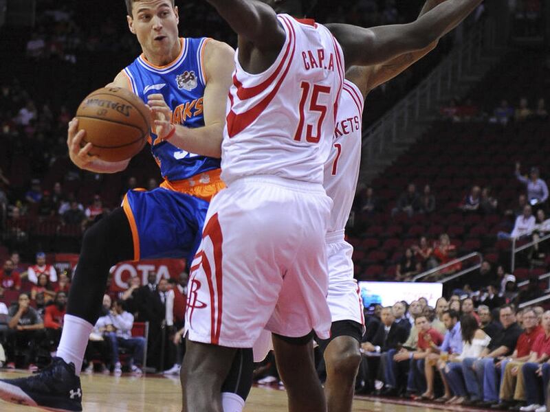 The Shanghai Sharks Jimmer Fredette, left, drives by the Houston Rockets Clint Cappella, right, in the first half of an NBA basketball exhibition game Sunday, Oct. 2, 2016, in Houston. (AP Photo/George Bridges)