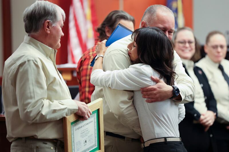 Al Palmer, Salt Lake County Veterans Treatment Court mentor coordinator, hugs Air Force veteran Elizabeth Torres as she graduates.