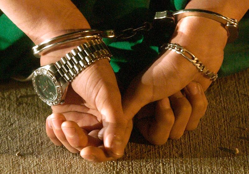 The handcuffed hands of an arrested gang suspect.