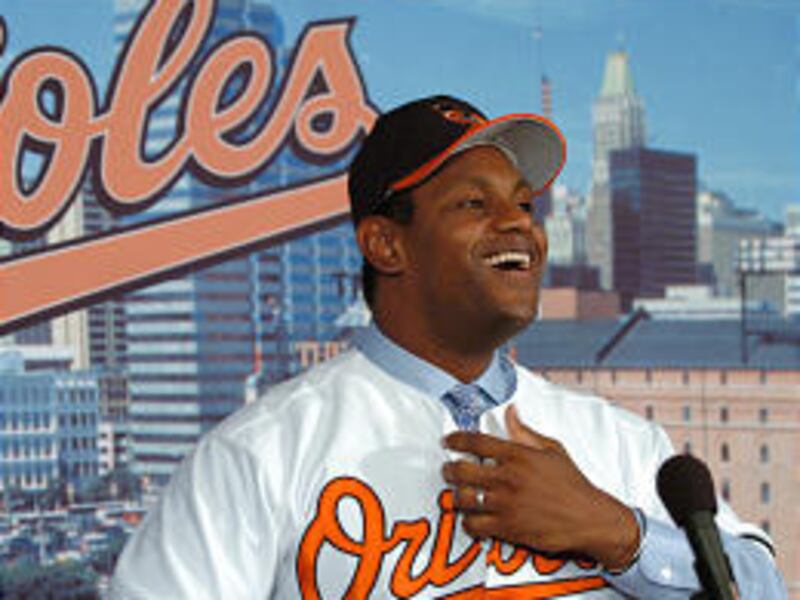 Sammy Sosa, the newest member of the Baltimore Orioles, smiles after trying on his jersey and hat.
