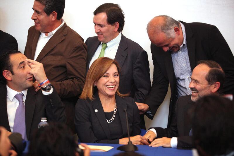 IDENTIFIES THE NAMES OF PARTY MEMBERS - Josefina Vazquez Mota, presidential candidate for the ruling National Action Party, PAN, bottom row center, laughs during a news conference with top members of her party in Mexico City, Monday April 9, 2012. The pre