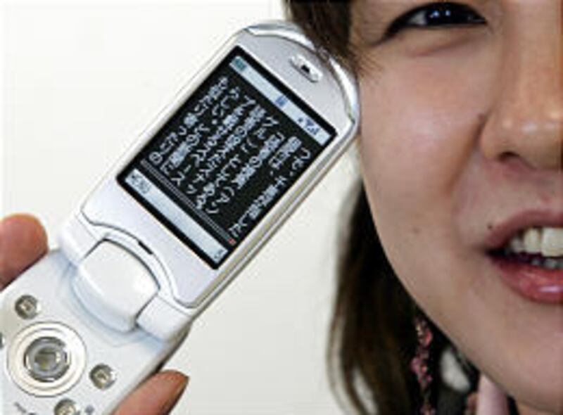 Satoko Kajita shows off her mobile phone that carries a novel on its screen at her office in Tokyo.