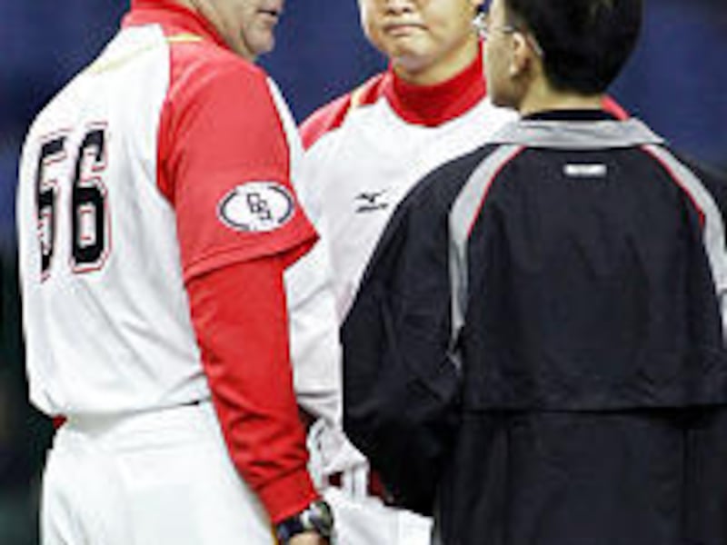Bruce Hurst (56) talks with China Stars pitcher Chen Kun, center, through an interpreter, right.