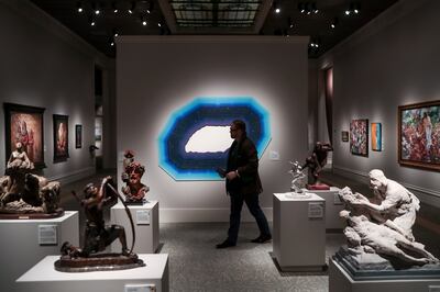 Micah Chistensen, founder of Zion Art Society, walks in front of "Lights of Night," an acrylic piece by Roland Thompson, while touring the 11th International Art Exhibition at the Church History Museum during a media preview in Salt Lake City on Tuesday,