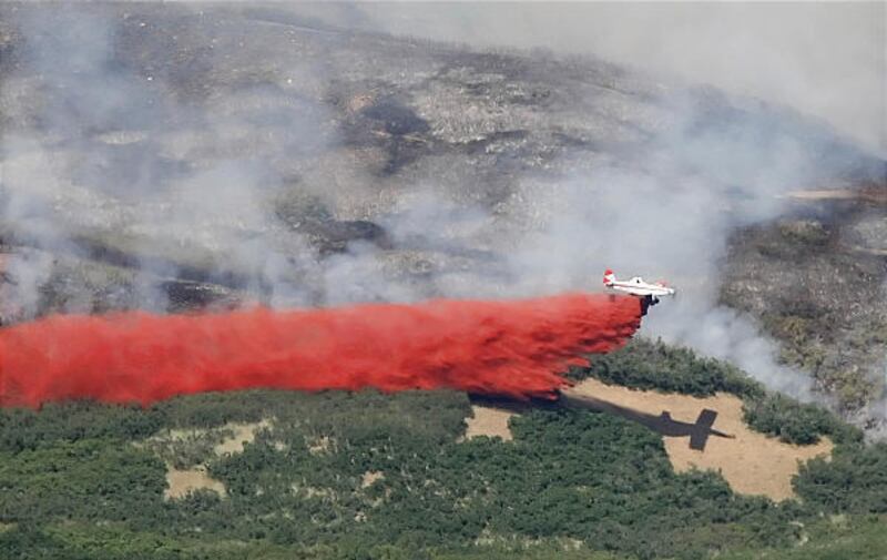 A small air tanker drops retardant on a fire in City Creek Canyon just northeast of Salt Lake City.