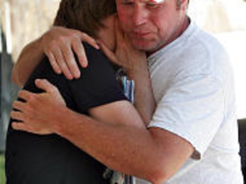 Fay Dolan, left, is consoled by brother Jim Andrus outside her home in Roy Tuesday. Dolan's son, Dan, was killed in Iraq Sunday.