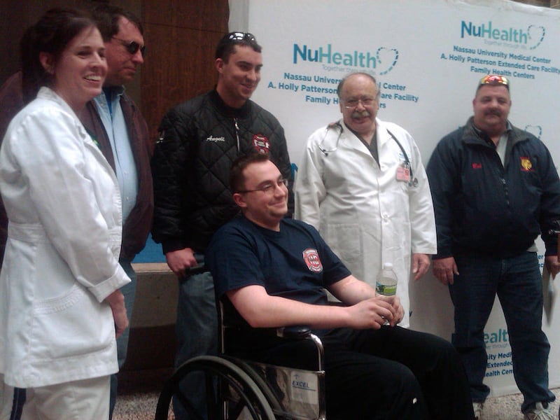 Justin Angell, center, a Long Island emergency medical technician with the Bellmore Fire Department, smiles as he is released from Nassau University Medical Center in East Meadow, N.Y., Thursday, March 3, 2011. Angell's brother Dean and father Gene, thir