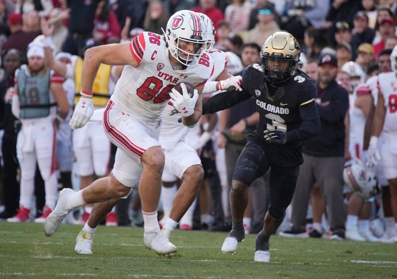 Utah tight end Dalton Kincaid, left, runs after catching a pass against Colorado, Saturday, Nov. 26, 2022, in Boulder, Colo.