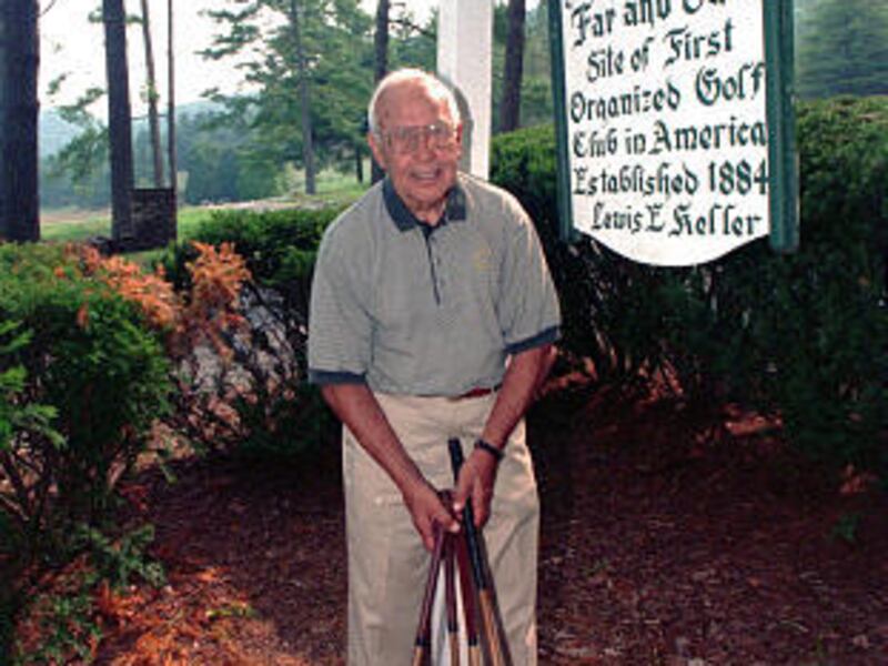 In this August 1999 file photo, Lewis Keller, owner of Oakhurst Links golf course in White Sulphur Springs, W.Va., poses at the entrance to the course.