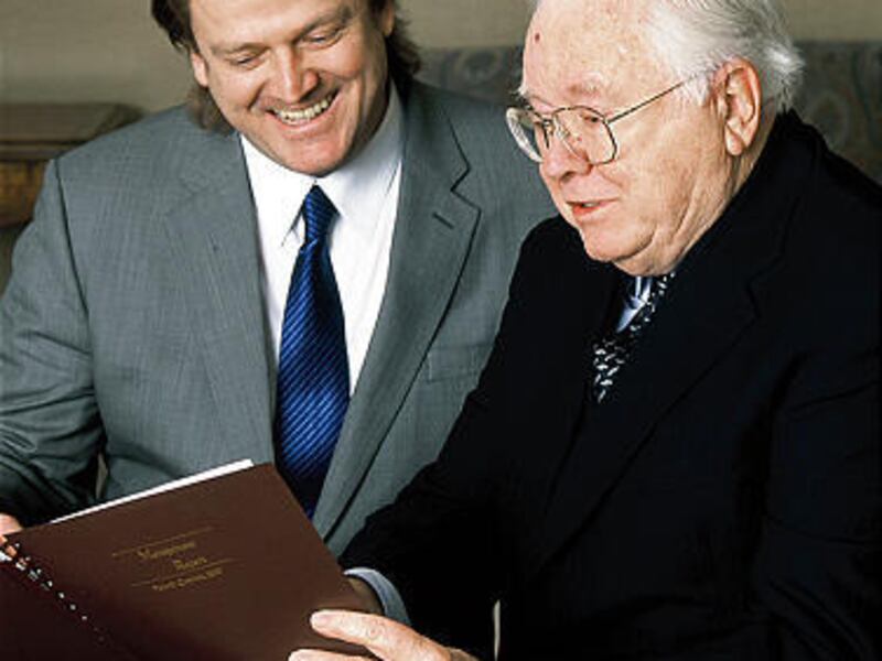 Jack Byrne, right, and his son Patrick — CEO of Overstock.com — look at a financial booklet in 2003.