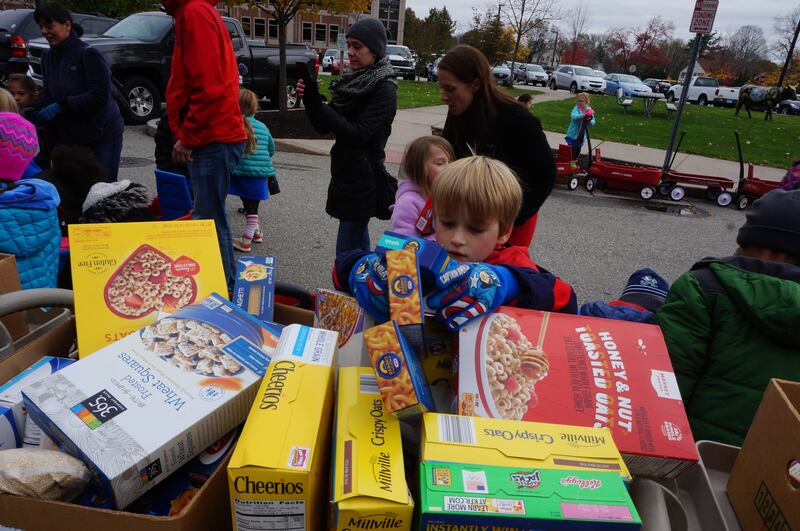 Children from Morley Elementary School in West Hartford, Connecticut, help organize donations for a food drive held each year in November. Hands-on service helps to build character in children, child-development experts say.