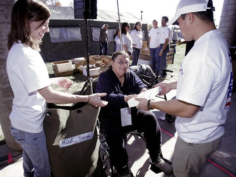 Alisha and Michael Gruber help Sharon Hatch load her duffel bag at the Homeless Stand Down Friday at the VA center.