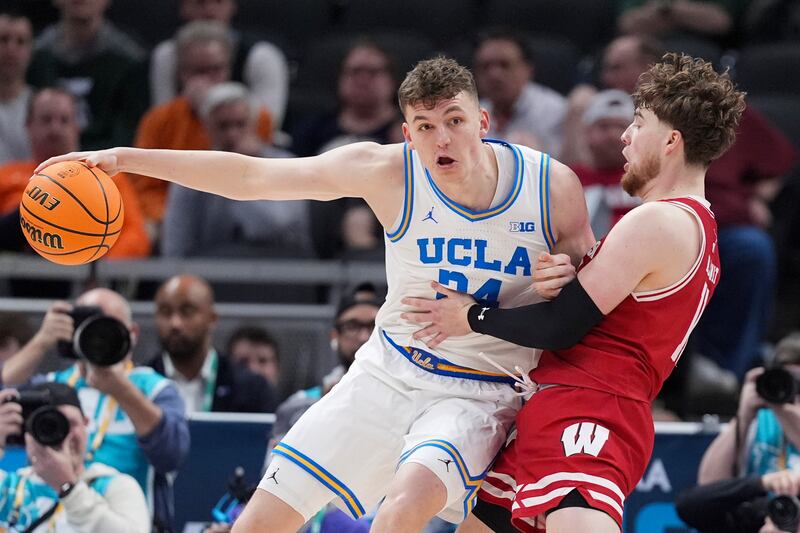 UCLA forward Tyler Bilodeau (34) drives on Wisconsin guard Max Klesmit (11) during game in the quarterfinals of the Big Ten tournament in Indianapolis, Friday, March 14, 2025.