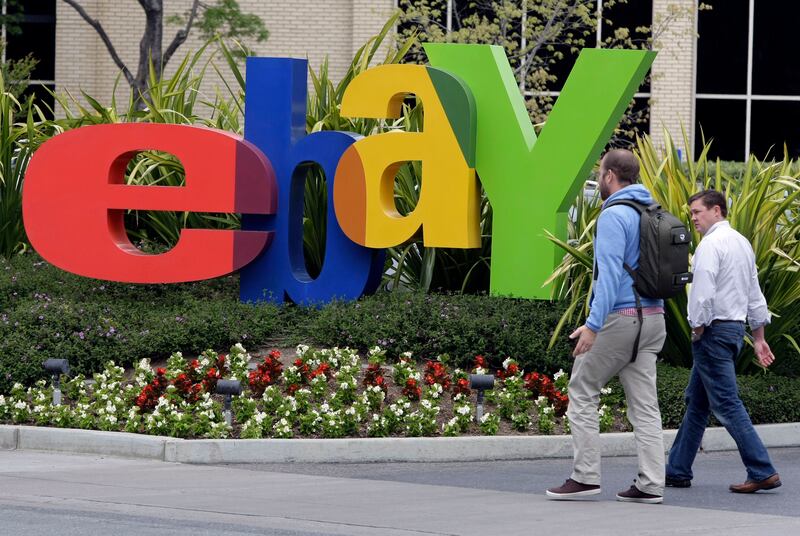 Two pedestrians pass eBay headquarters in San Jose, Calif.