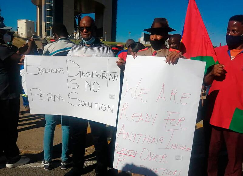 People hold banners as they stage a protest in Windhoek, Namibia.