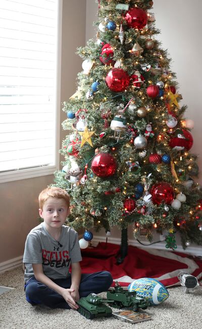 Kempton Kirkwood sits by a Christmas tree at his home in Farmington on Thursday, Dec. 27, 2018, as his mother, Lesha Kirkwood, explains how one of the batteries in the infrared laser tag gun set that Kempton got for Christmas exploded in his face.