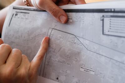 FILE - In this April 1, 2019, file photo, Mindy Nagel points to her home on a congressional district map of her neighborhood in Cincinnati. Nagel's home is split by two House districts. The Supreme Court said, by a 5-4 vote on Thursday, June 27, 2019, tha