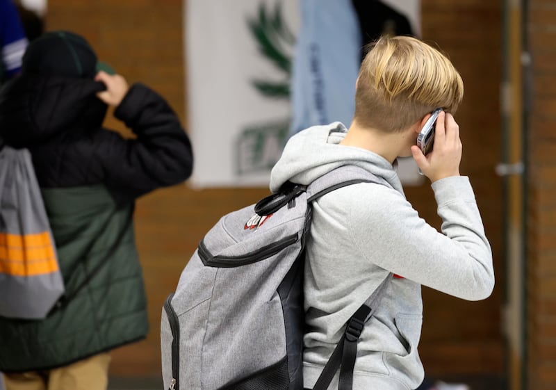A student uses a cellphone after school at Evergreen Junior High School in Millcreek on Jan. 10, 2024.