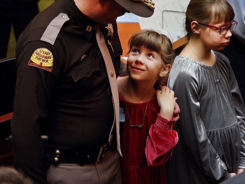 Maise Ward, a daughter of Sgt. Craig Ward, who died in 2022, looks up at Utah High Patrol Trooper Capt. Cody McCoy who was Sgt. Ward’s supervisor at the time of his death. The Utah House of Representatives honored families of first responders at the Capitol in Salt Lake City on Friday, Feb. 10, 2023.