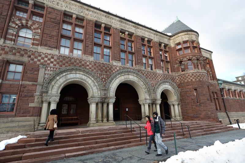 Passersby walk near an entrance to a building at Harvard Law School, in Cambridge, Mass., on Dec. 5, 2019.