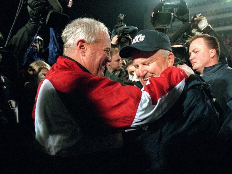 Utah coach Ron McBride, left, congratulates BYU coach LaVell Edwards following Edwards' last game as coach on Nov. 24, 2000. The Cougars prevailed, 34–27.