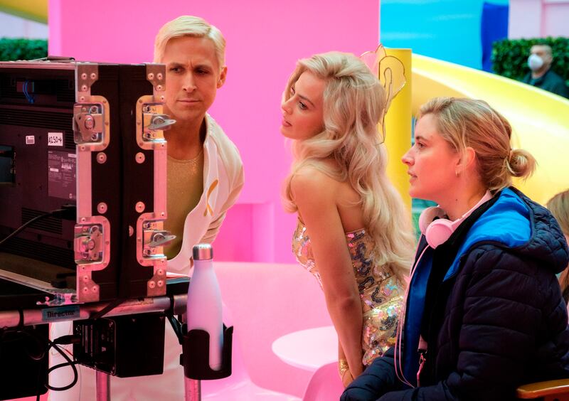 This image released by Warner Bros. Pictures shows actors Ryan Gosling, left, Margot Robbie, center, with director Greta Gerwig on the set of “Barbie.”
