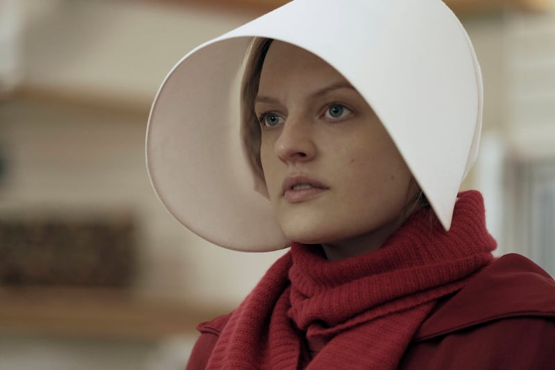 This image released by Hulu shows Elisabeth Moss as Offred in a scene from the critically acclaimed, “The Handmaid’s Tale.” Nominations for the 75th annual Golden Globes will be announced on Monday, Dec. 11, 2017. (George Kraychyk/Hulu via AP)