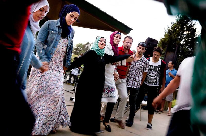Baraa Huraideen and her husband, Malek Hamad, dance with family and members of the Muslim community at an Eid al-Fitr party in Sugarhouse Park on June 26.