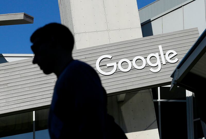 In this Nov. 12, 2015, file photo, a man walks past a building on the Google campus in Mountain View, Calif.