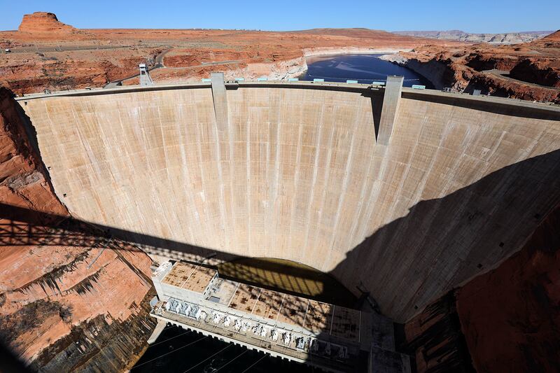 Glen Canyon Dam on a sunny day with Lake Powell behind it.