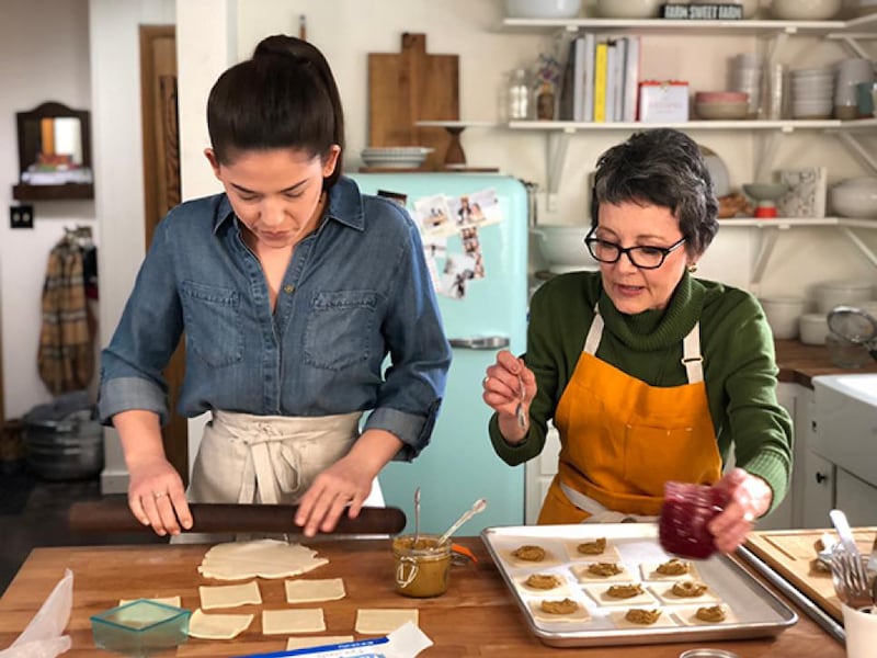 Molly Yeh rolls out pastry dough while her mother-in-law, Roxanne Hagen, places pistachio butter on her Pocket Pastries with Raspberry Jam.