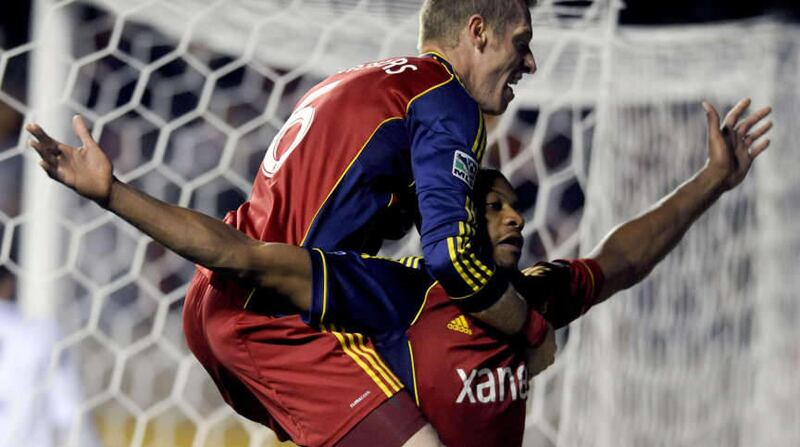 Real Salt Lake defender Nat Borchers (6) jumps onto Real Salt Lake defender Chris Schuler (28) following Schuler's goal in overtime during a playoff game at Rio Tinto Stadium on Thursday, November 7, 2013.