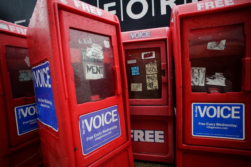 In this Nov. 27, 2013 photo, plastic newspaper boxes for The Village Voice stand along a Manhattan sidewalk in New York. Village Voice publisher Peter Barbey announced on Friday, Aug. 31, 2018, that the venerable alternative weekly will cease publication.