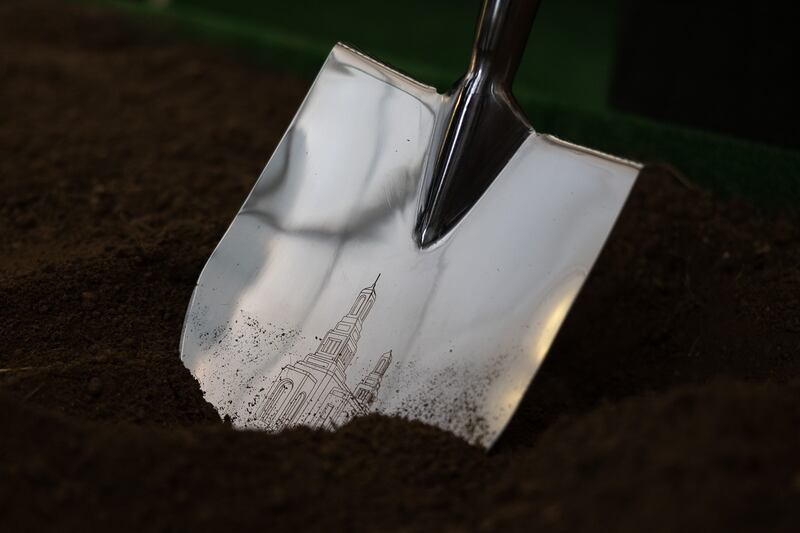 A close-up of a silver shovel with the outline of the future Wellington New Zealand Temple.