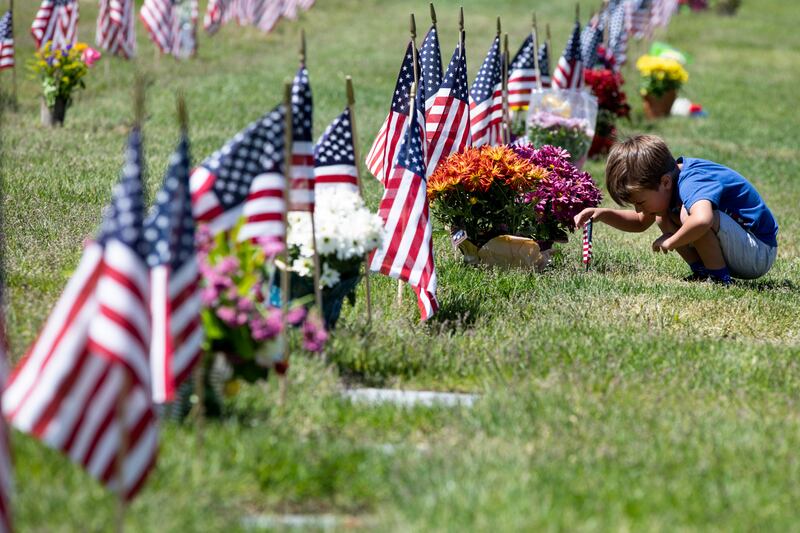 A young boy looks at gravesite at Utah Veterns Cemetary and Memorial Park on Memorial Day 2020.
