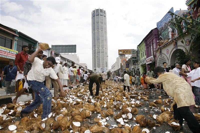 Malaysian Hindu devotees smash coconuts during the annual Thaipusam festival, an event symbolizing the struggle between good and evil, in Penang Island, Malaysia, on Saturday. The festival is rooted in Hindu legend and was brought from southern India by 1