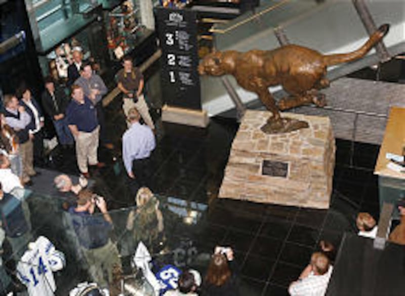 BYU alumni and others look at and photograph the cougar statue that was unveiled Friday at the BYU Student Athlete Building.